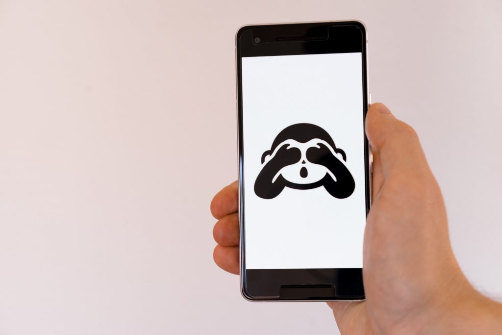 Emoji of a monkey covering its eyes on a phone