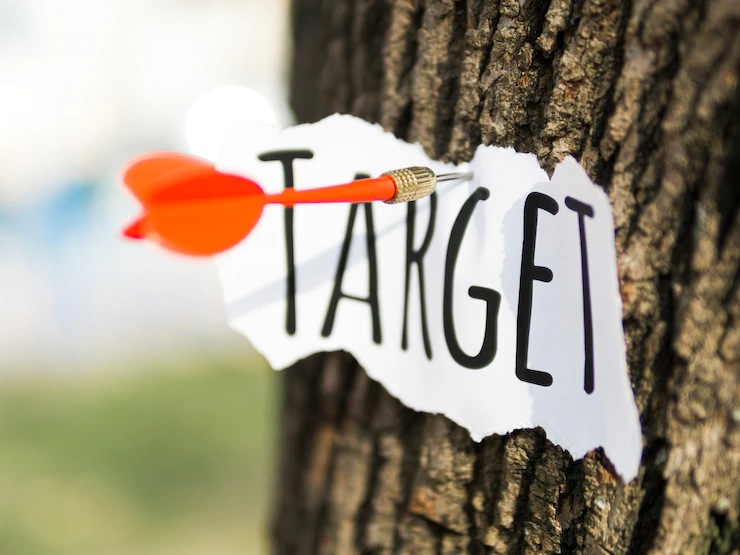 A piece of paper with target stuck to the tree. Reach your goals every time by setting SMS Marketing KPIs.