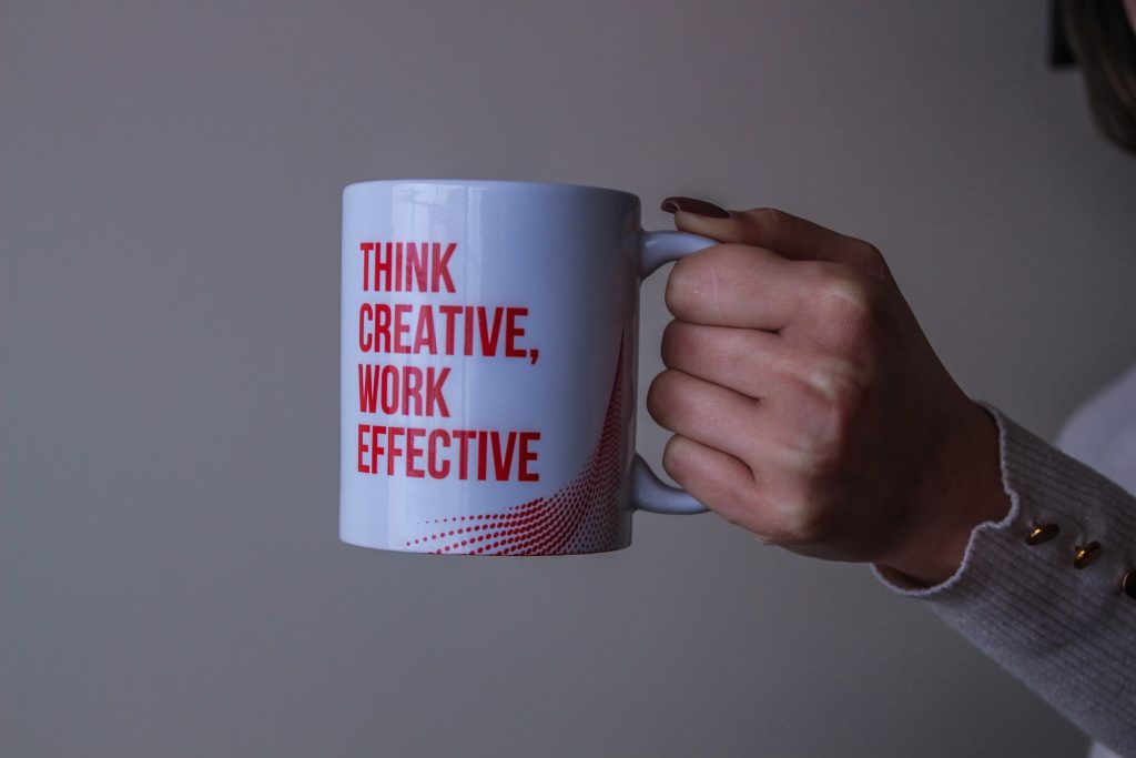 A mug that has “Think creative, work effective” written on it. Explore different B2B SMS marketing use cases and never run out of ideas for effective marketing.