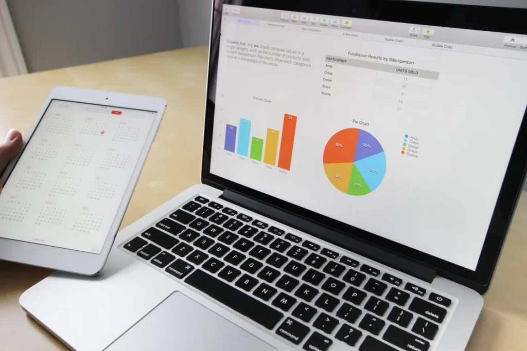 Charts and graphs on the laptop screen that represent how you can track and analyze your SMS marketing KPIs.