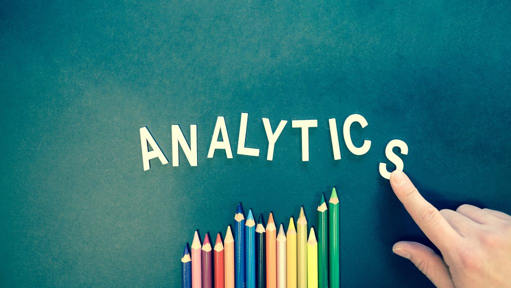 Analytics written above colored pencils. Use SMS analytics to analyze & improve your performance.